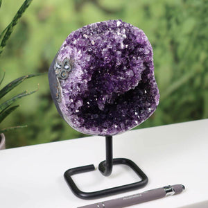 Amethyst Drusen Geode from Uruguay on display with metal stand, very dark purple crystals visible, perfect for home decor