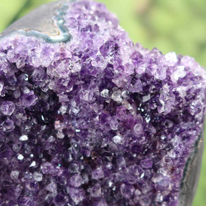 Close-up view of a vibrant, dark purple Uruguay Amethyst druse with naturally regular crystals, showcasing intense sparkle and rich color.