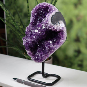 Deep purple Uruguay amethyst geode on metal stand displaying rich, natural crystal formation, ideal for home decor.