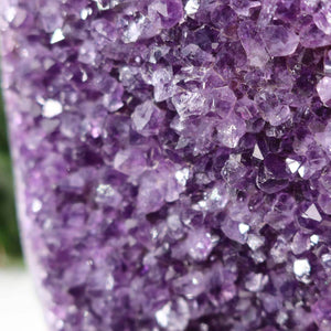 Close-up view of a dark purple Uruguay Amethyst Druse showcasing its naturally regular and sparkling crystals.