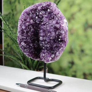 Amethyst Drusen Geode from Uruguay on metal stand, displaying dark purple crystals, enhancing home decor.