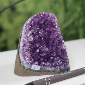 Uruguay Amethyst mini geode with intense purple crystals and label number 12, displayed outdoors.