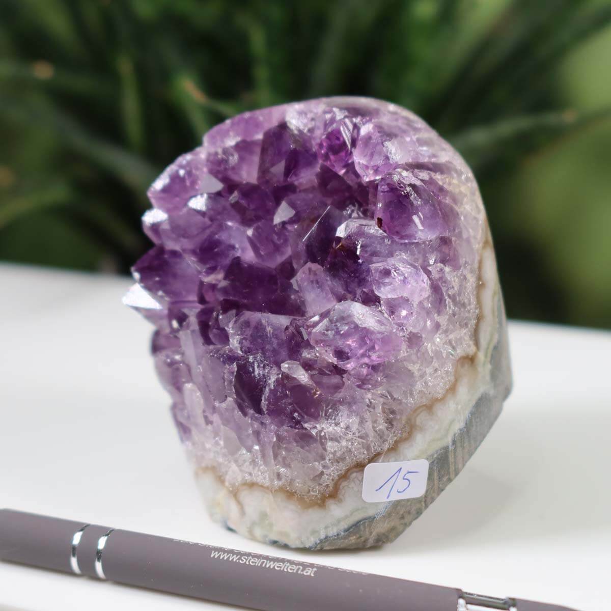 Uruguay Amethyst Mini Geode with intense purple crystals, labeled as unique piece number 15, displayed on a desk with a pen for scale.