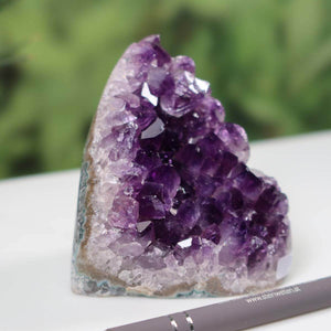 Intense purple Uruguay Amethyst mini geode displayed outdoors, showcasing its regular crystal formation and deep color.