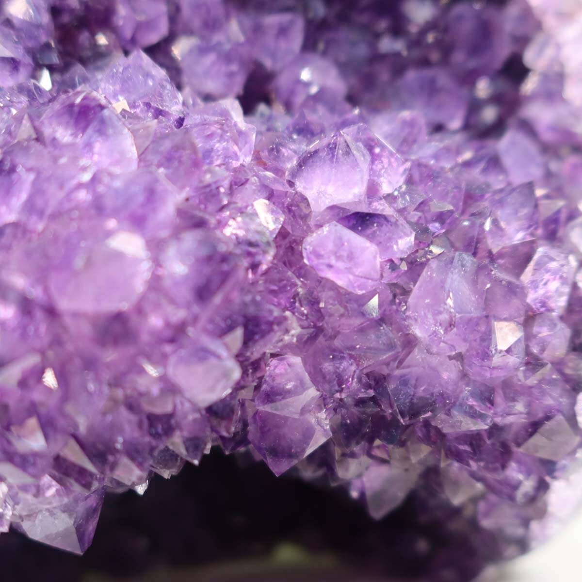 Close-up of a vibrant Uruguay Amethyst Mini Geode showing deep violet crystals with intense sparkle, unique specimen NR 18.