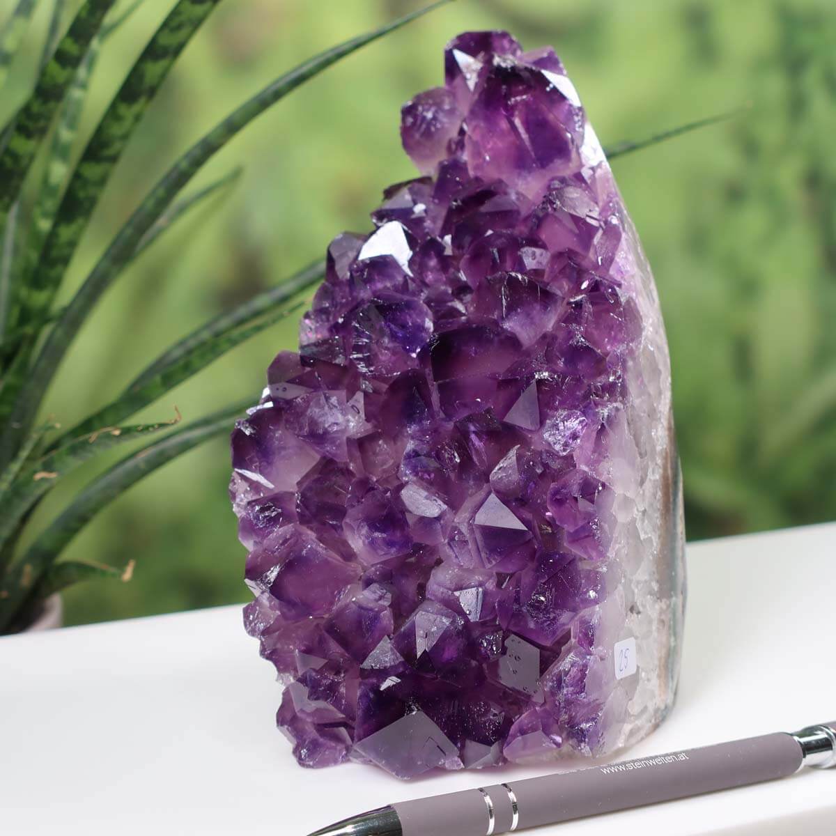 Intense purple Uruguay Amethyst mini geode with distinct crystal formation, labeled number 25, displayed with a pen for scale.