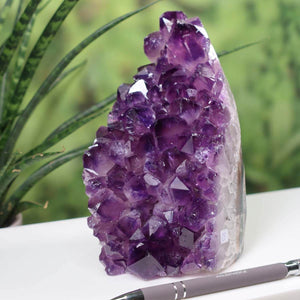 Uruguay Amethyst Mini Geode with deep violet crystals, displayed beside a pen for scale, showcasing its natural, intense sparkle and rich color.