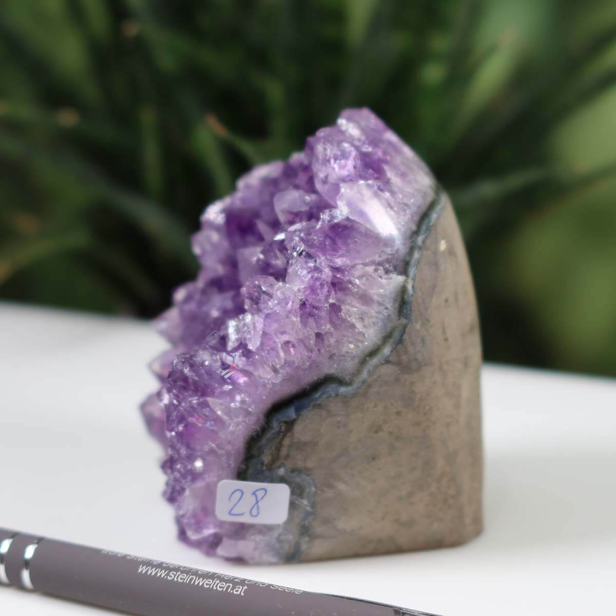 Uruguay Amethyst Mini Geode with rich purple crystals, labeled number 28, displayed on a table.