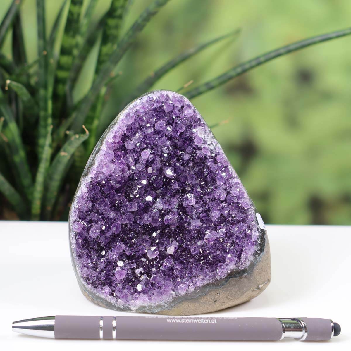 Intense purple Uruguay amethyst mini geode with natural crystal formation showcased beside a pen for scale