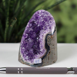 Uruguay Amethyst Mini Geode with intense violet crystals and number 41 on a table, pen for scale