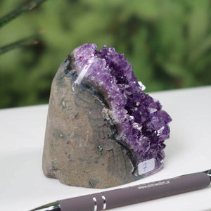 Intense purple Uruguay Amethyst mini geode on display, marked as unique piece number 7, featuring regular crystal formations.