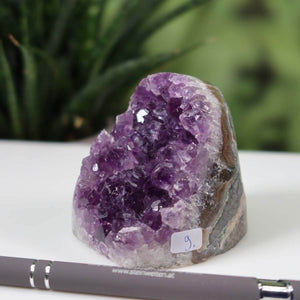 Intense purple Uruguay Amethyst mini geode with crystal clusters, unique piece labeled NR 9, displayed with a silver pen.