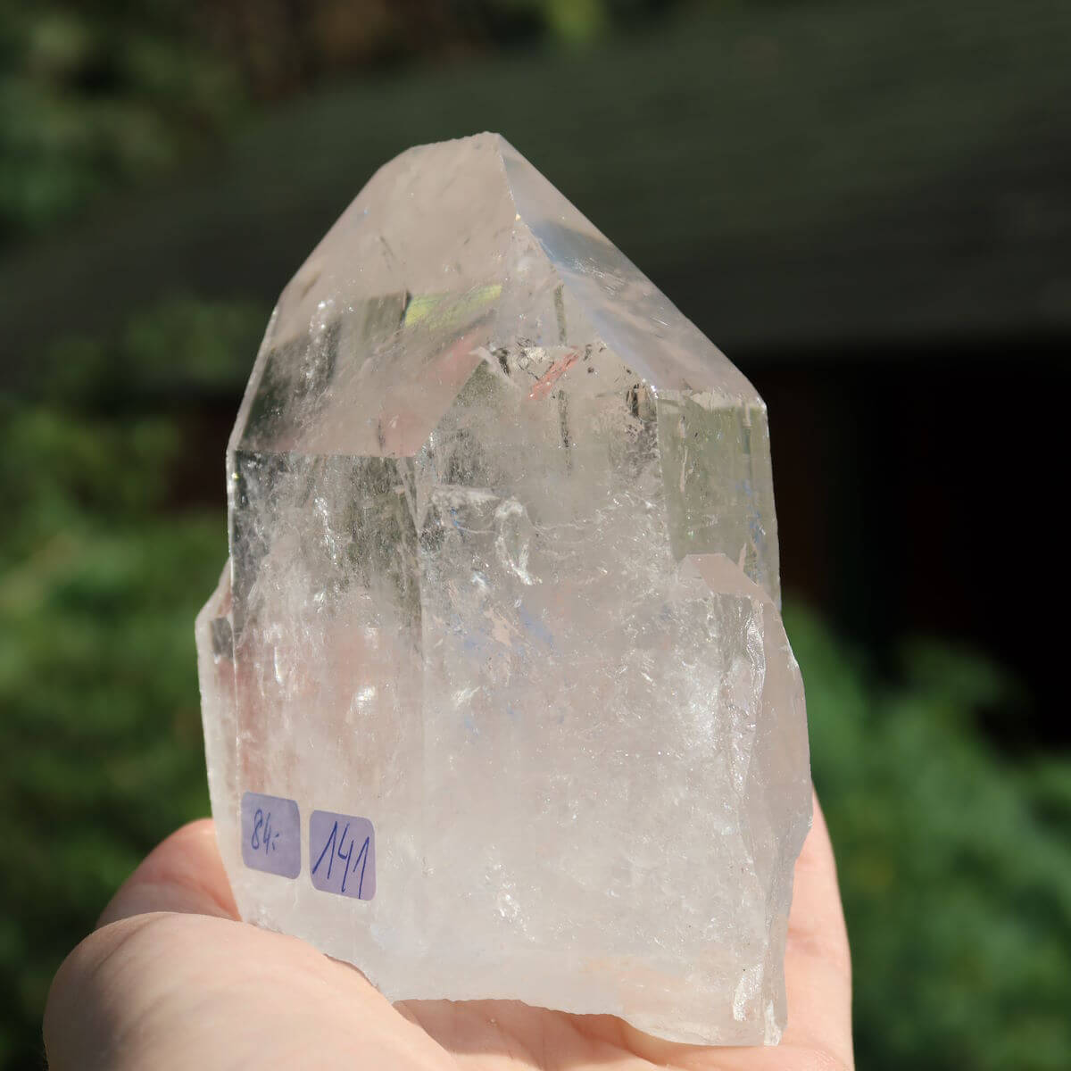 Clear quartz crystal point from Brazil, unique cut for clarity and meditation, 10x8 cm, hand-held with natural sparkle.