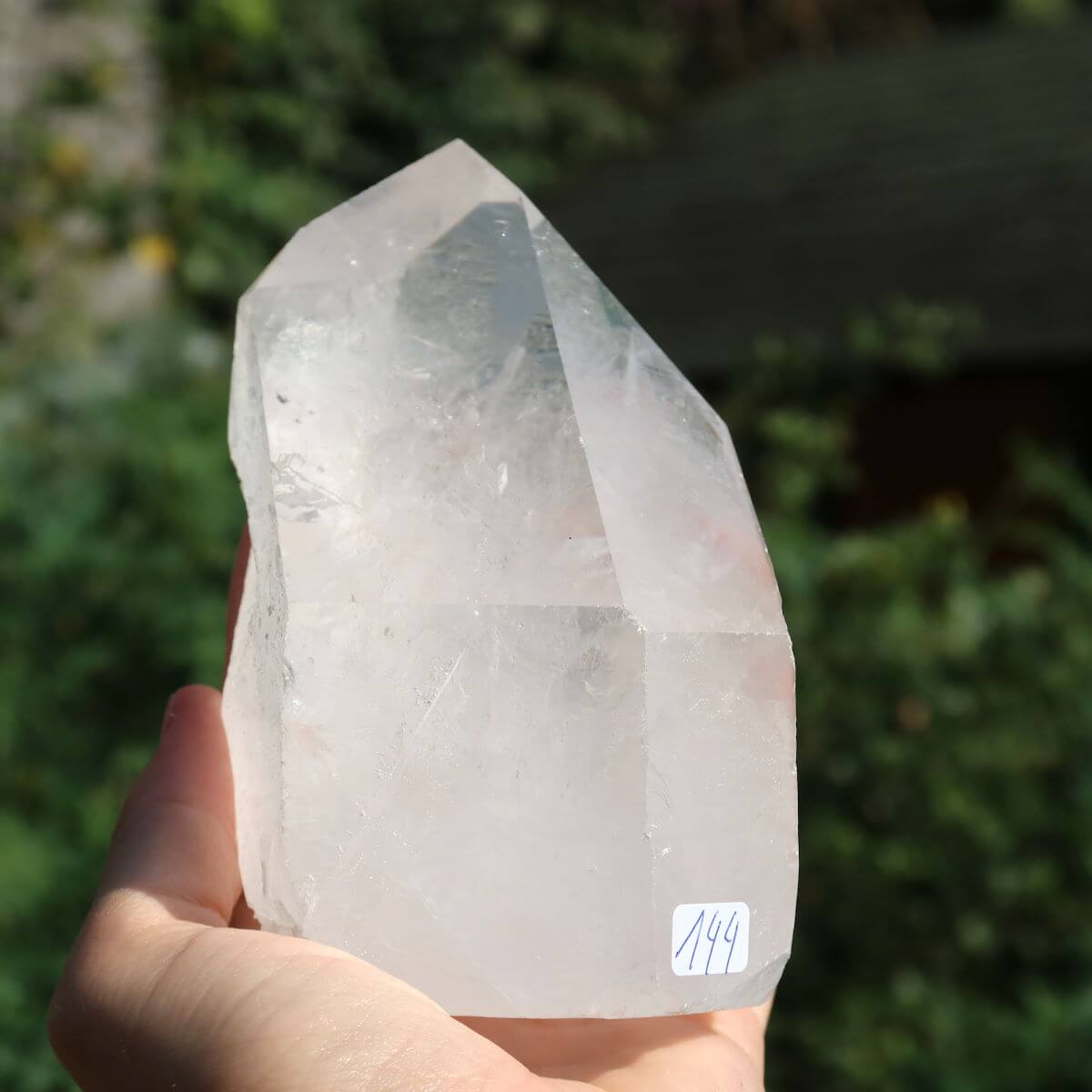 Hand holding a unique, cut quartz crystal point measuring 12x6 cm, ideal for clarity and meditation, sourced from Brazil.