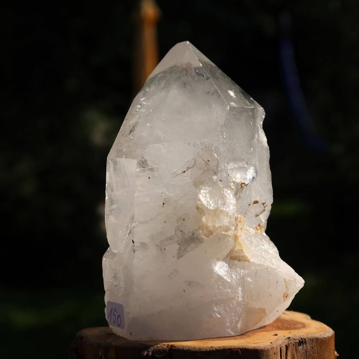 Polished quartz crystal point, unique specimen No. 150 from Brazil, stands on wood, perfect for clarity and meditation.