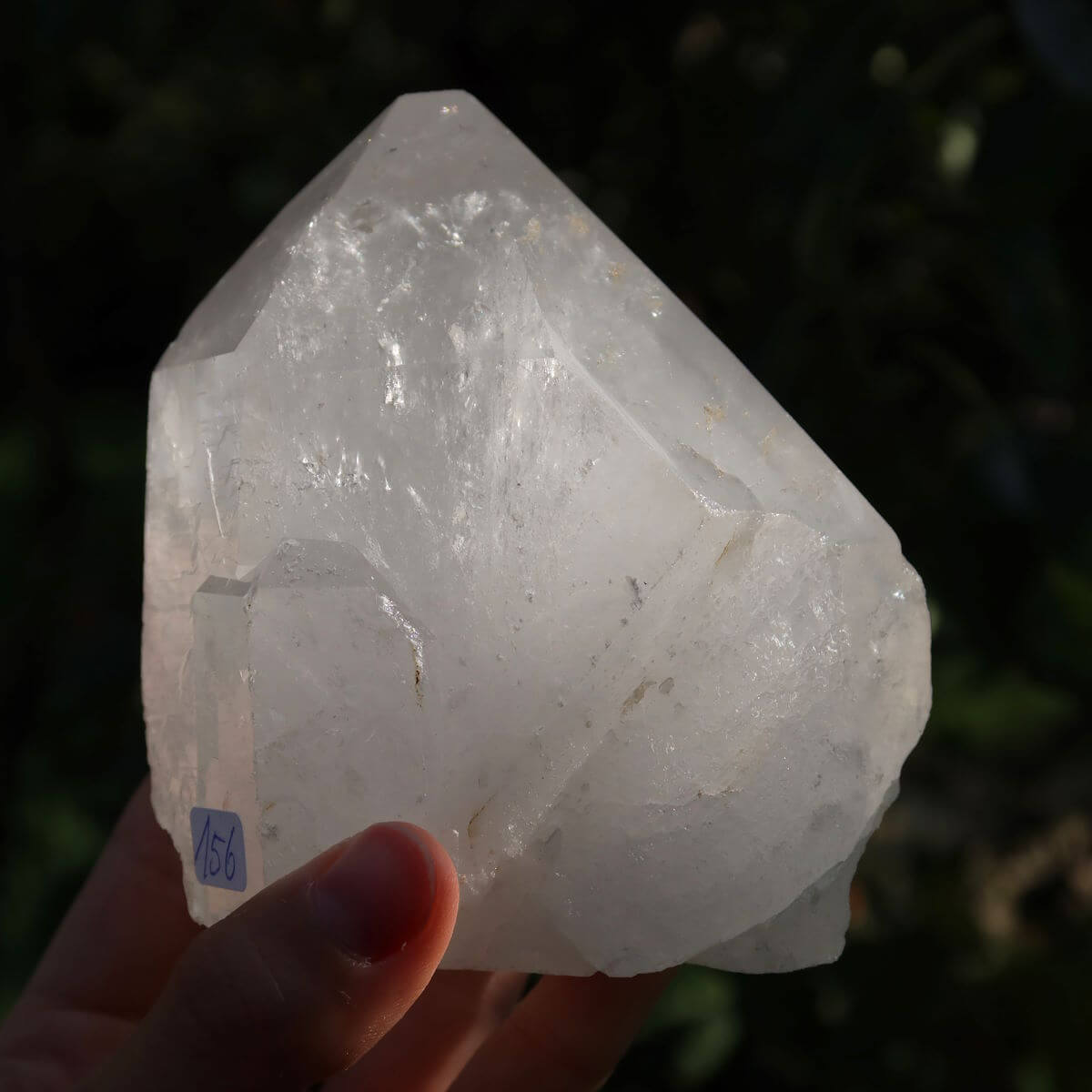 Hand holding polished quartz crystal point, 9x9 cm, from Brazil, showcasing natural clarity and facets for meditation.