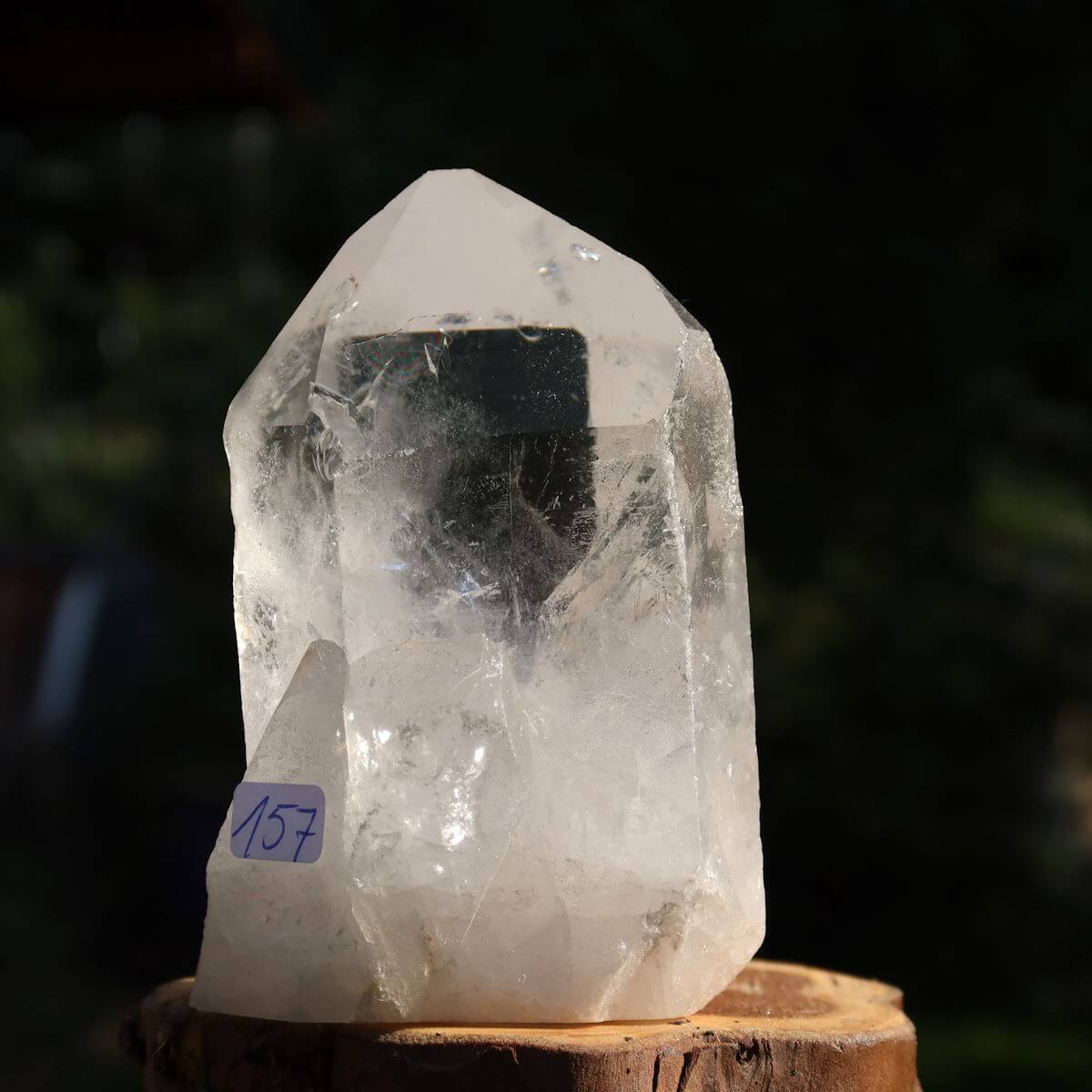 Clear quartz crystal point from Brazil with unique facets, standing on wooden base, labeled number 157, ideal for clarity and meditation.