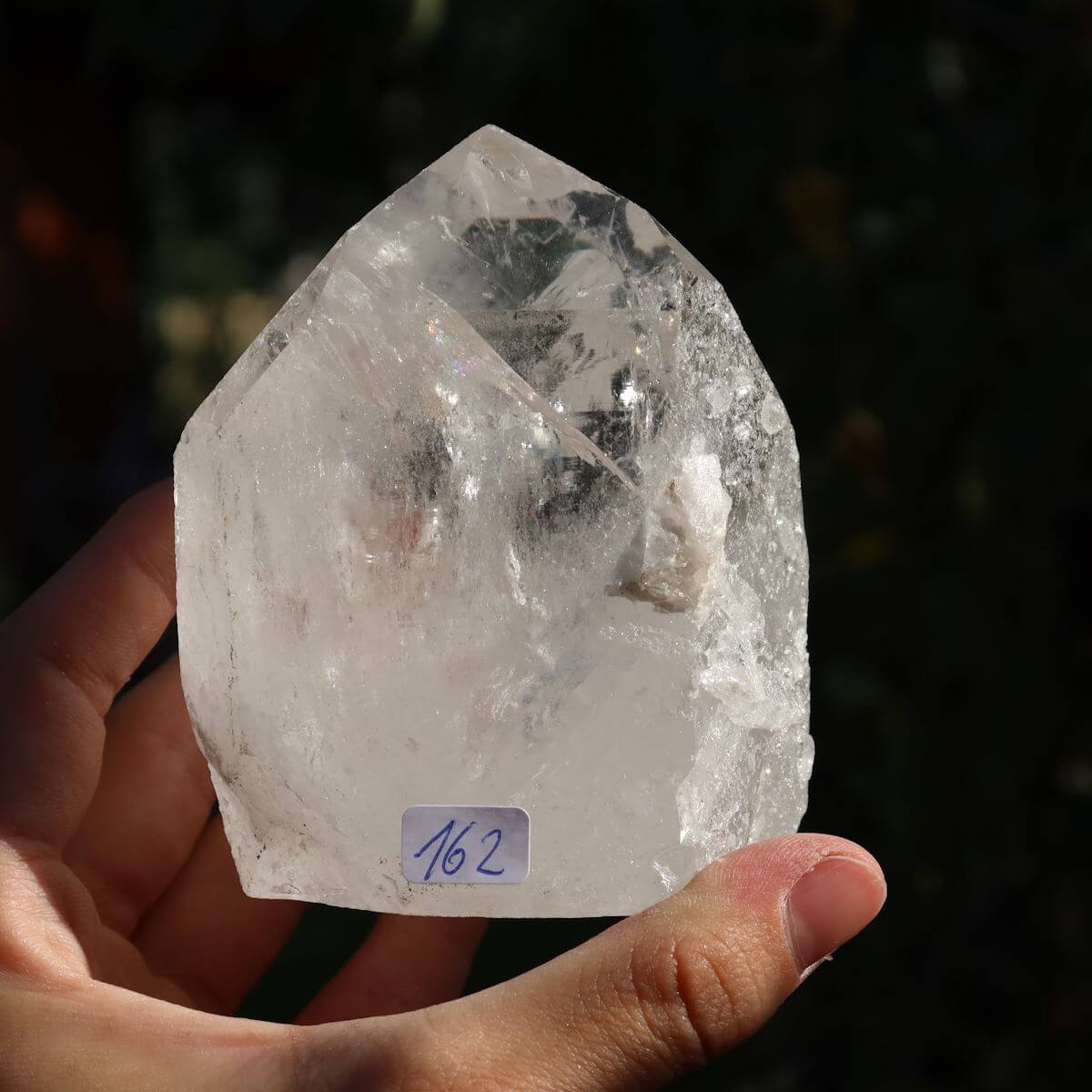 Person holding a unique Brazilian quartz crystal point, Bergkristall Unikat Nr. 162, with polished facets for clarity and meditation.