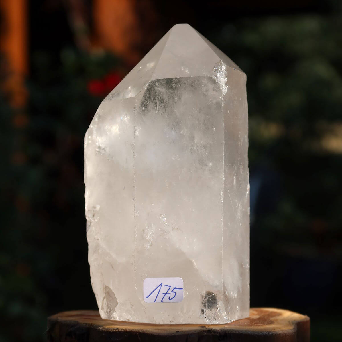 Hand holding polished Bergkristall Quarz Crystal Point Nr.175 from Brazil for meditation, 10x6 cm, reflecting light with clarity.