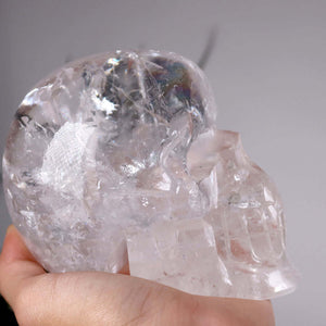 Hand holding a unique crystal skull made of clear quartz, demonstrating intricate details and clarity, titled "UNIKAT Nr. 1"