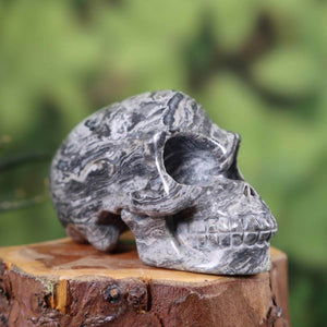 Handcrafted natural stone skull with unique patterns, 8x4 cm. Exclusive collectible sold online by Steinwelten.