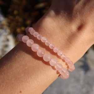 Elegantes Rosenquarz Edelstein Armband auf schmalem Handgelenk, erhältlich in 4-6-8mm Variationen, für Liebe und Style.